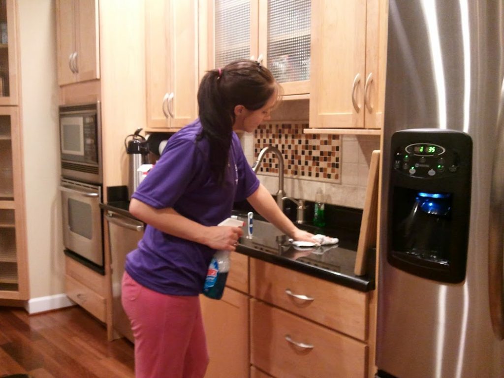 Thai Cleaning Service team member wiping down the kitchen sink